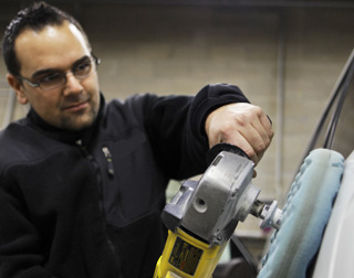 Technician waxing vehicle